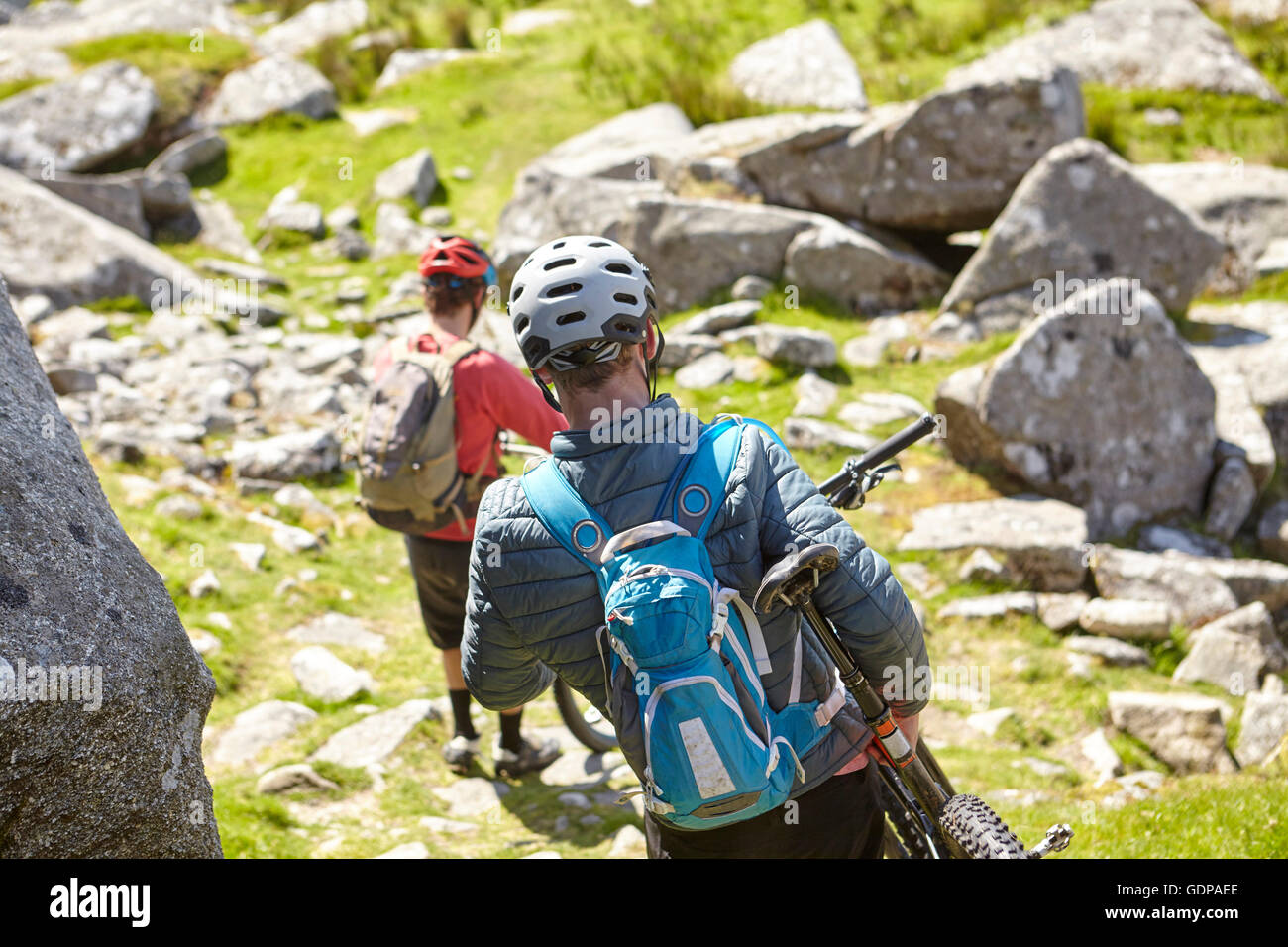 Radfahrer tragen Fahrräder auf Felsvorsprung Stockfoto