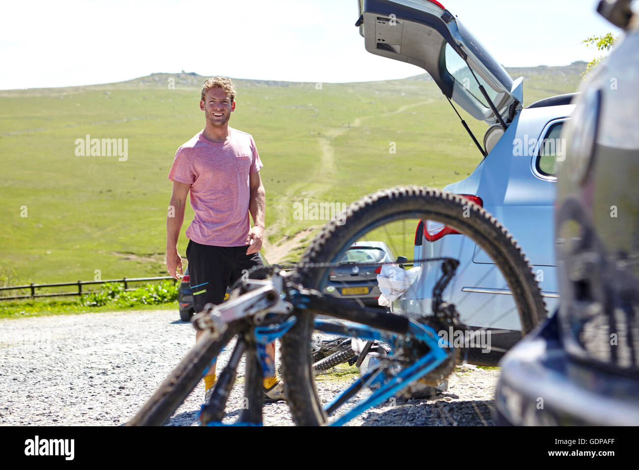 Radfahrer mit Fahrrad von Kofferraum, Blick auf die Kamera zu Lächeln Stockfoto