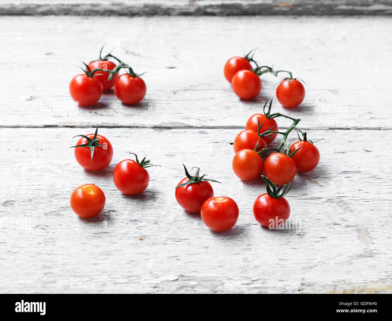 Cherry-Tomaten weiß getünchten Holzoberfläche Stockfoto