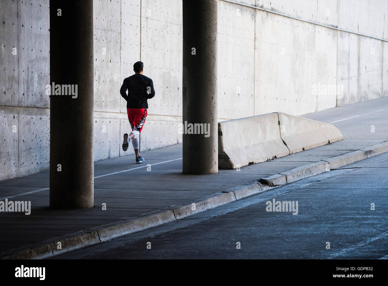 Junge männliche Läufer läuft in Stadt Unterführung Stockfoto