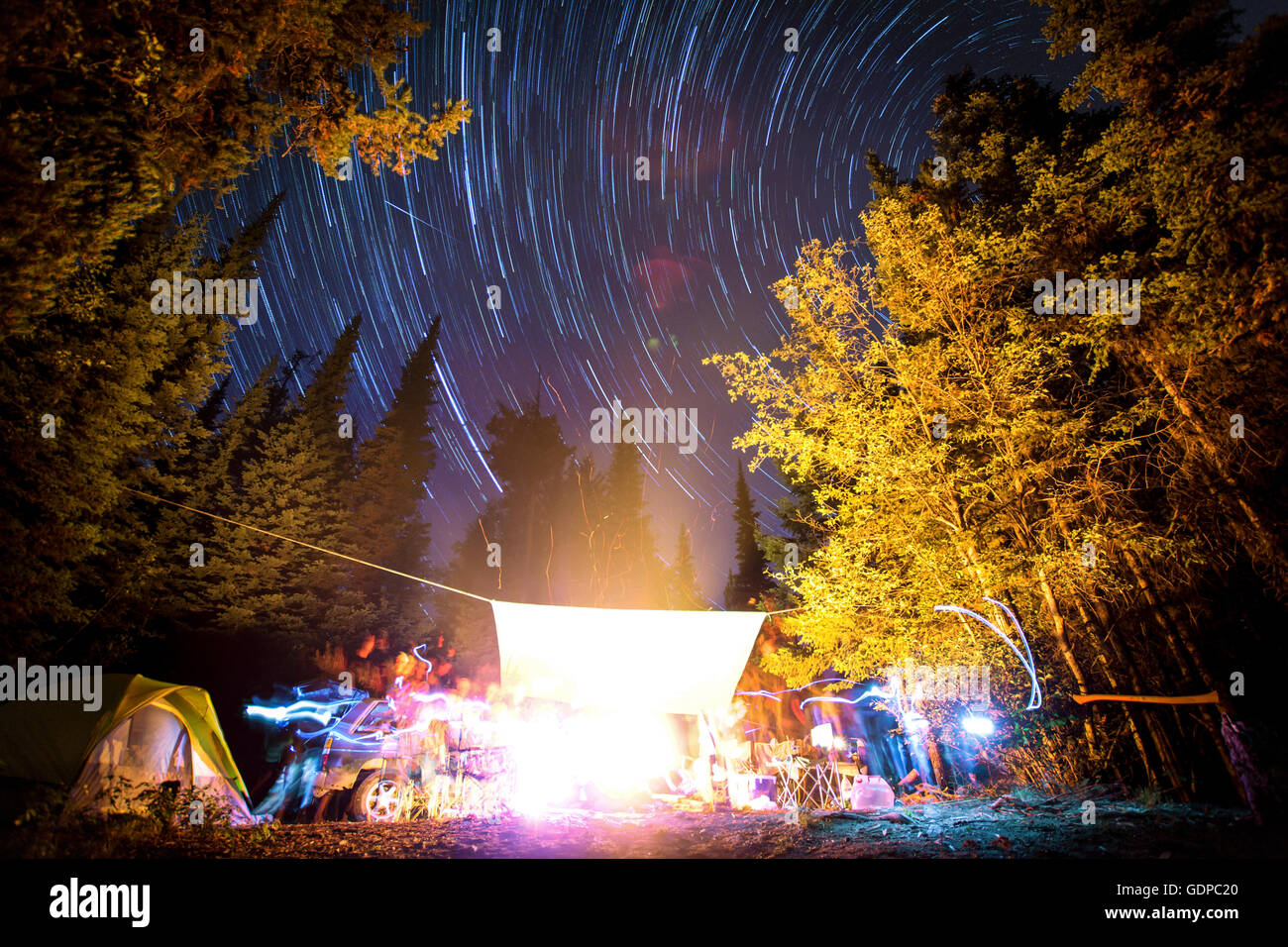 Langzeitbelichtung der Sterne am Nachthimmel und Lichtspuren Lagerfeuer, Elinor See Naherholungsgebiet, Naramata, BC, Kanada Stockfoto