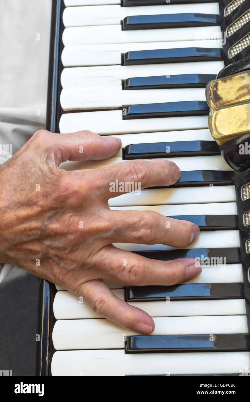 Einzelheiten über eine Hand auf eine alte Akkordeon während des Spielens. Selektiven Fokus. Stockfoto