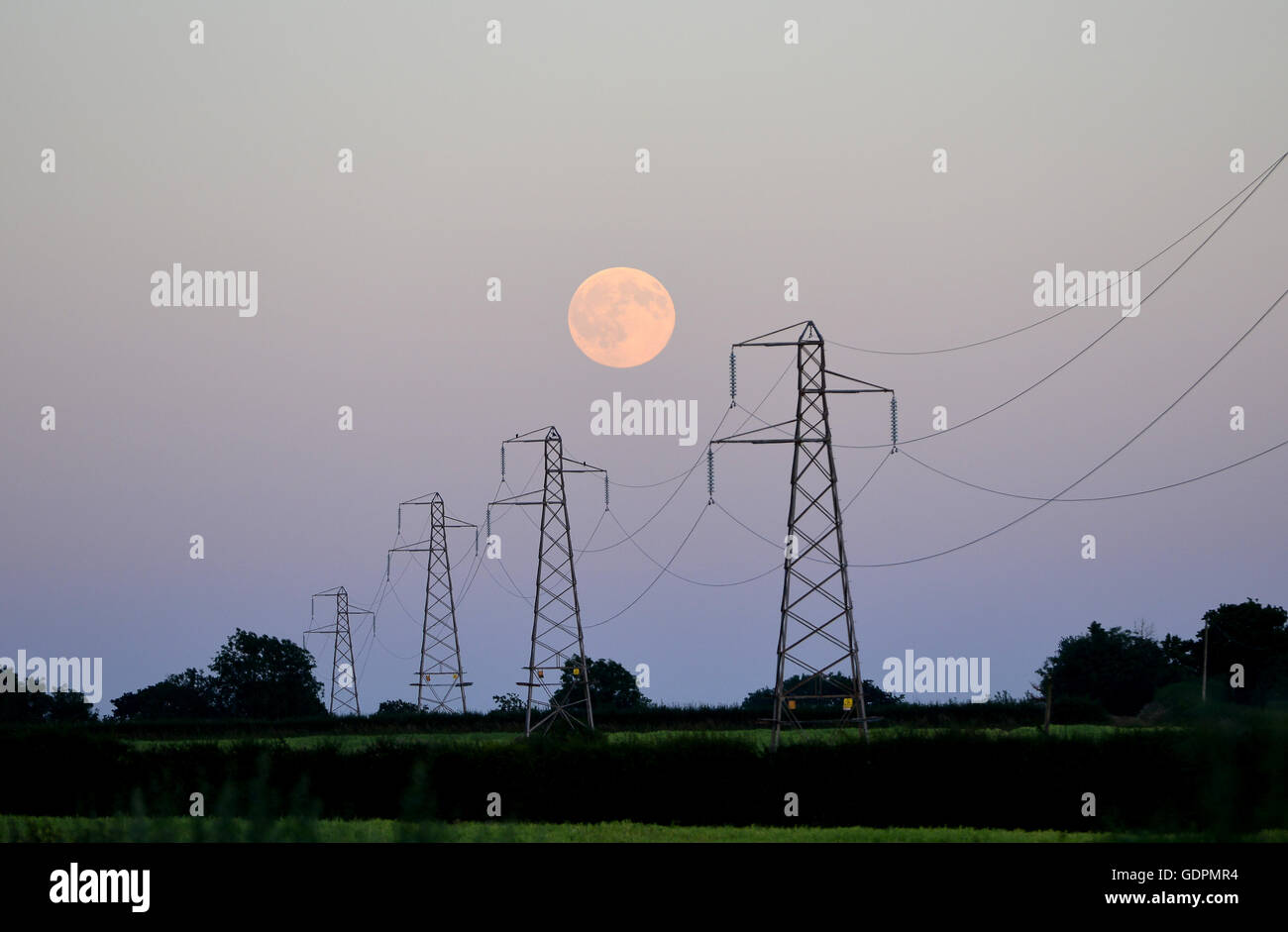 Full Moon rising hinter Strommasten Stockfoto