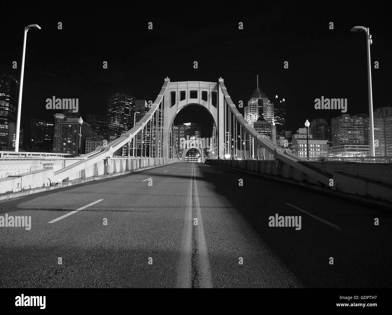 Schwarz und weiß auf der Brücke in die Innenstadt von Pittsburgh.  Mit dem Schein der Baseball-Stadion Lichter beleuchtet. Stockfoto
