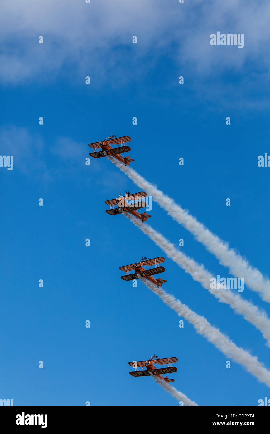 4 orange Boeing Stearman Doppeldecker in Formation am Himmel als Bestandteil der Breitling Wingwalker Kunstflug anzeigen Stockfoto