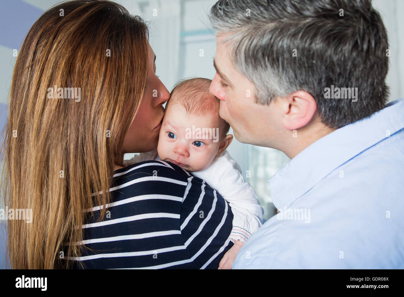 Stolze Eltern halten Baby im Schlafzimmer Stockfoto