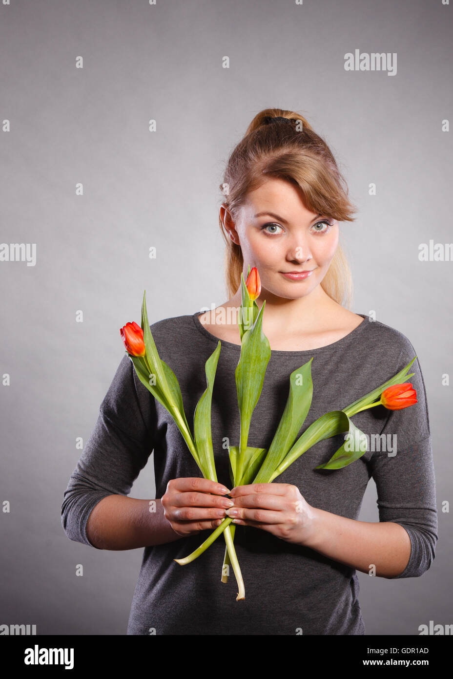Menschen und Blumen. Mädchen lieben die Natur, die rote grüne Tulpe Feder Blume. Frau anbetenden Natur. Stockfoto