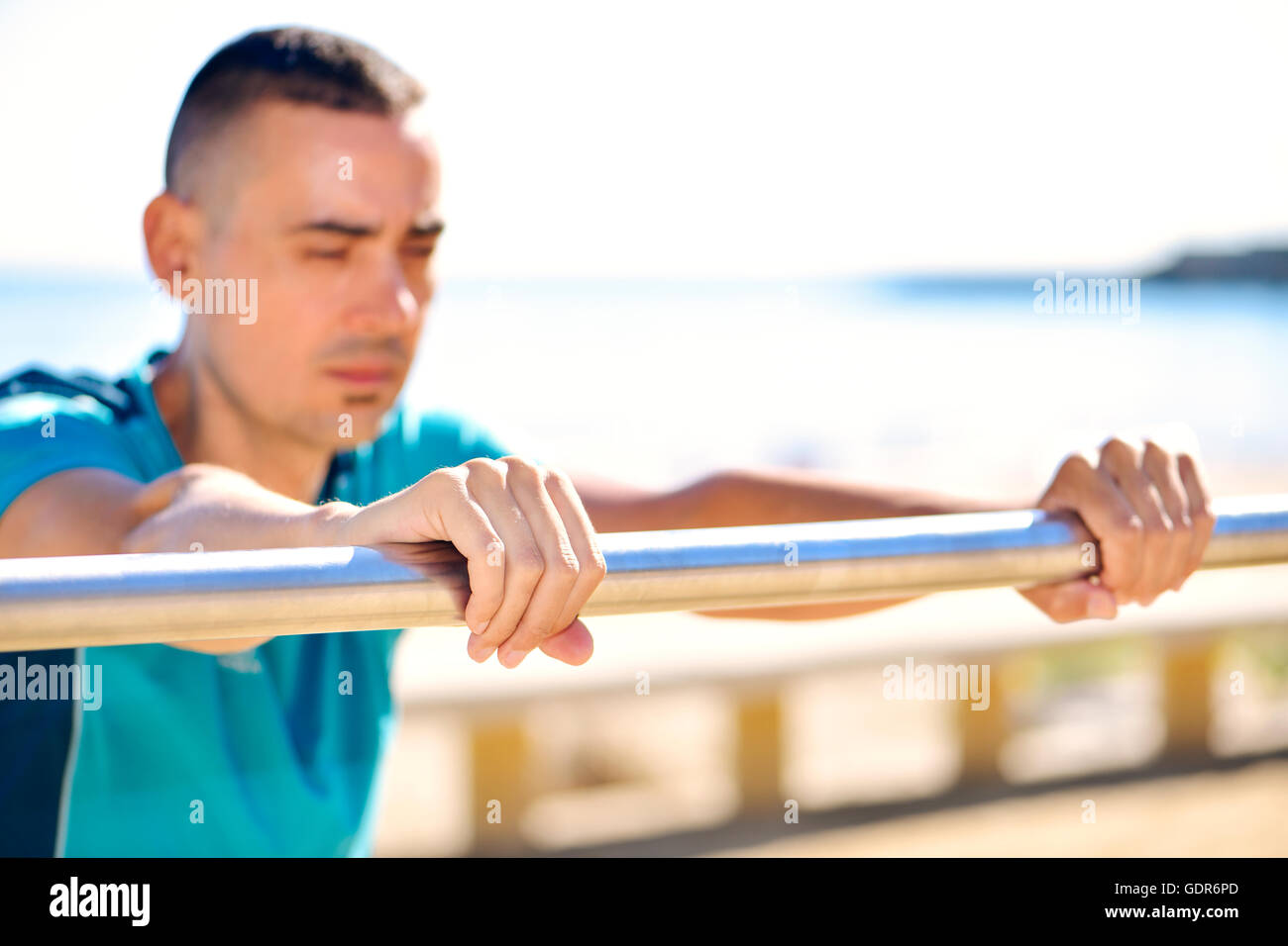 Nahaufnahme eines jungen kaukasischen Sportlers Sport Kleidung tun Steigung Liegestütze im Freien direkt am Meer Stockfoto