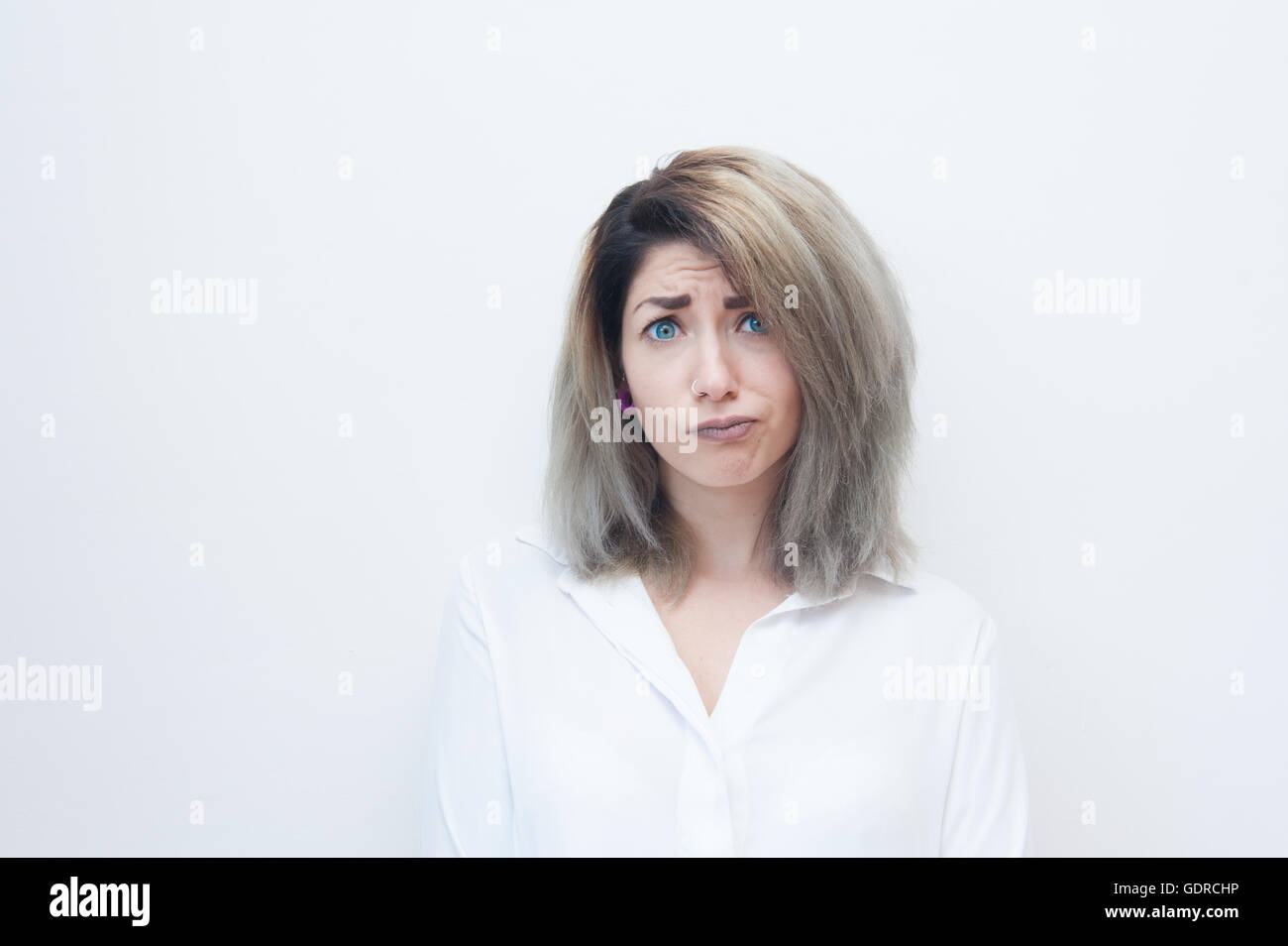 Junge blaue Augen blonde Frau frustriert Blick in die Kamera auf weißem Hintergrund Stockfoto