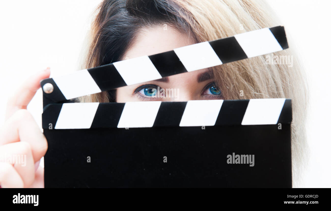 Junge blaue Augen blonde Frau Schauspielerin hautnah mit Film Klöppel hinter Gesicht Stockfoto