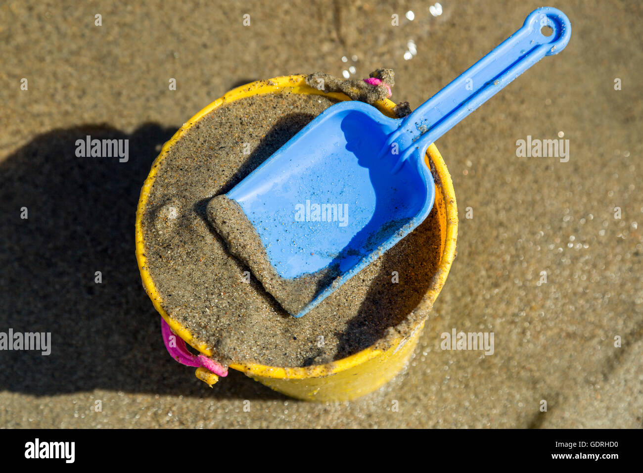 Spielzeug Schaufel und Eimer an einem Strand mit Sand. Stockfoto