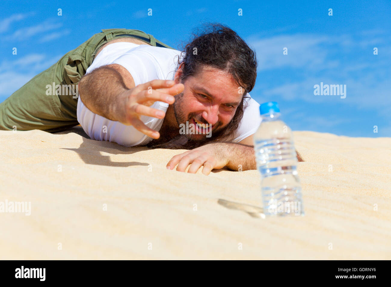 durstige Mann greift nach einer Flasche Wasser Stockfoto