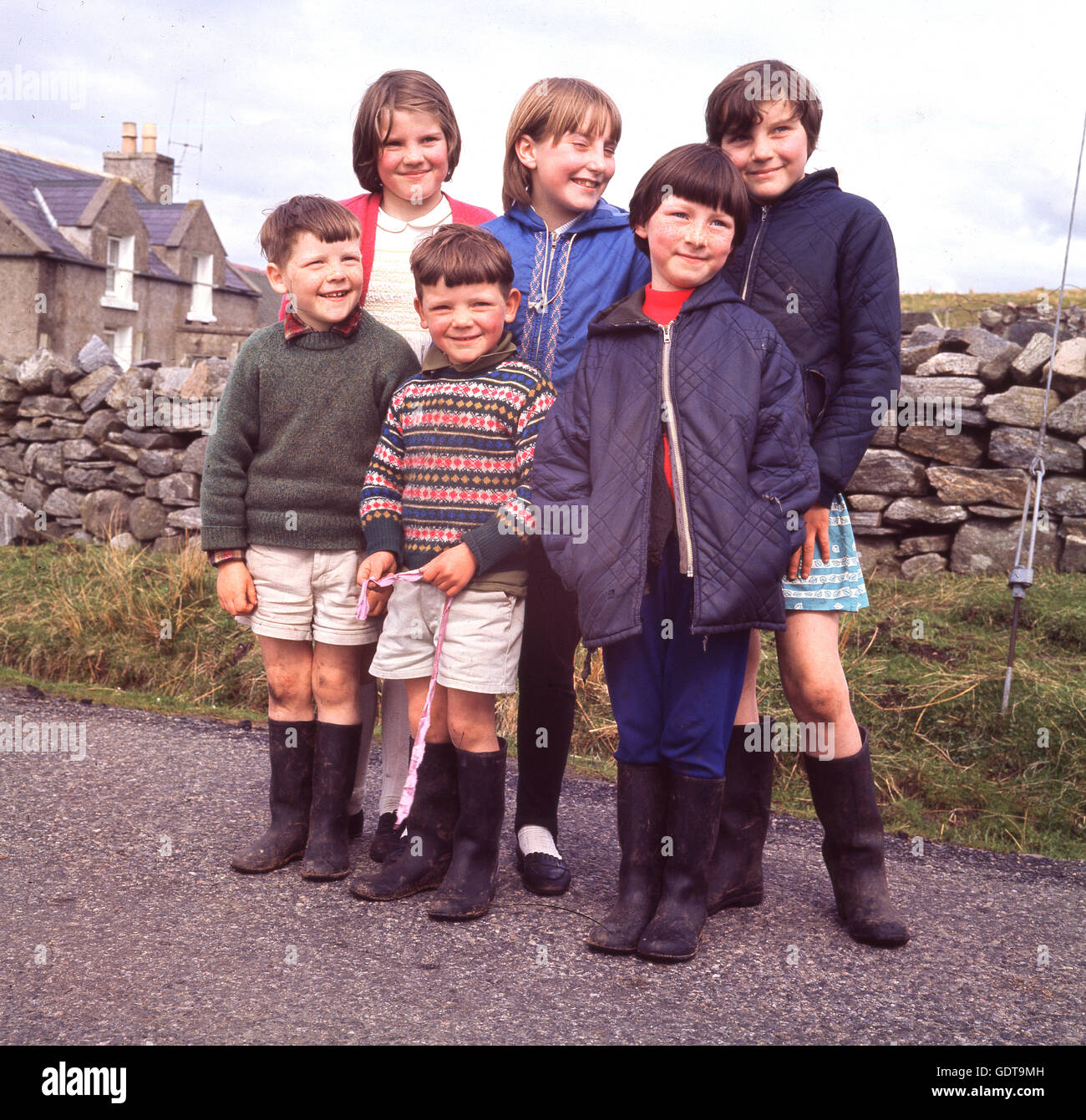 In den 1970er Jahren steht eine Gruppe glücklicher Kinder, fast alle mit wellington-Stiefeln, zusammen für ihr Foto in der Nähe des Dorfes Callanish auf der Isle of Lewis, der größten Insel der Äußeren Hebriden, Highlands, Schottland, Großbritannien, in diesem historischen Bild, das von J Allan Cash aufgenommen wurde. Stockfoto
