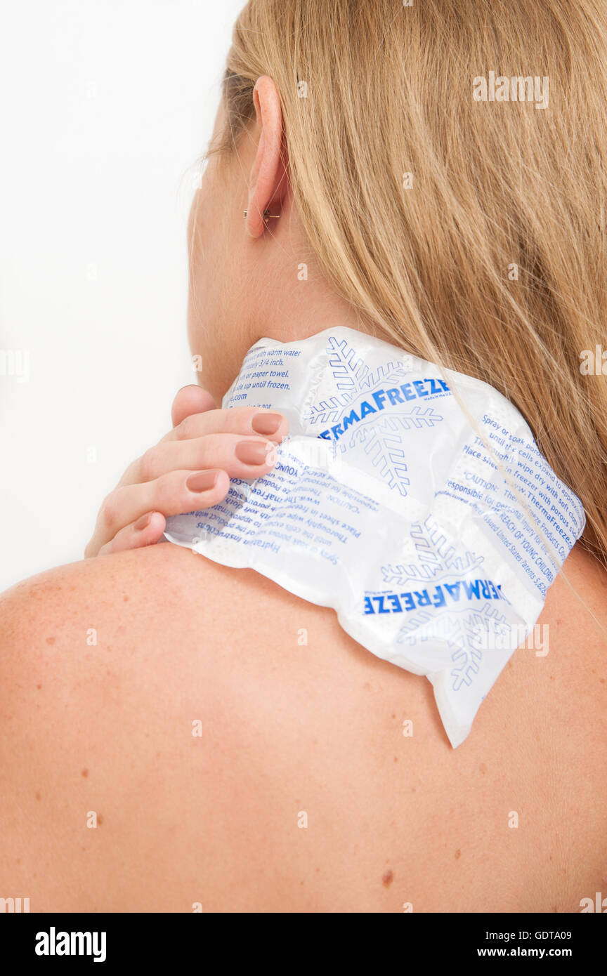 Weibliche Holding eine thermafreeze Ice Pack auf ihrer Schulter mit Schmerzen und Beschwerden zu helfen Stockfoto