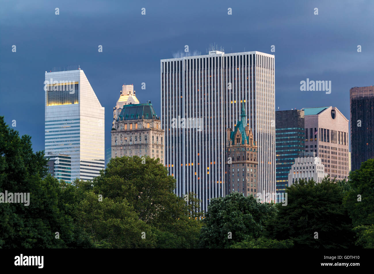 New York City Gebäude und Wolkenkratzer in der Abenddämmerung vom Central Park (Manhattan Midtown) mit einer stürmischen Abendhimmel betrachtet Stockfoto