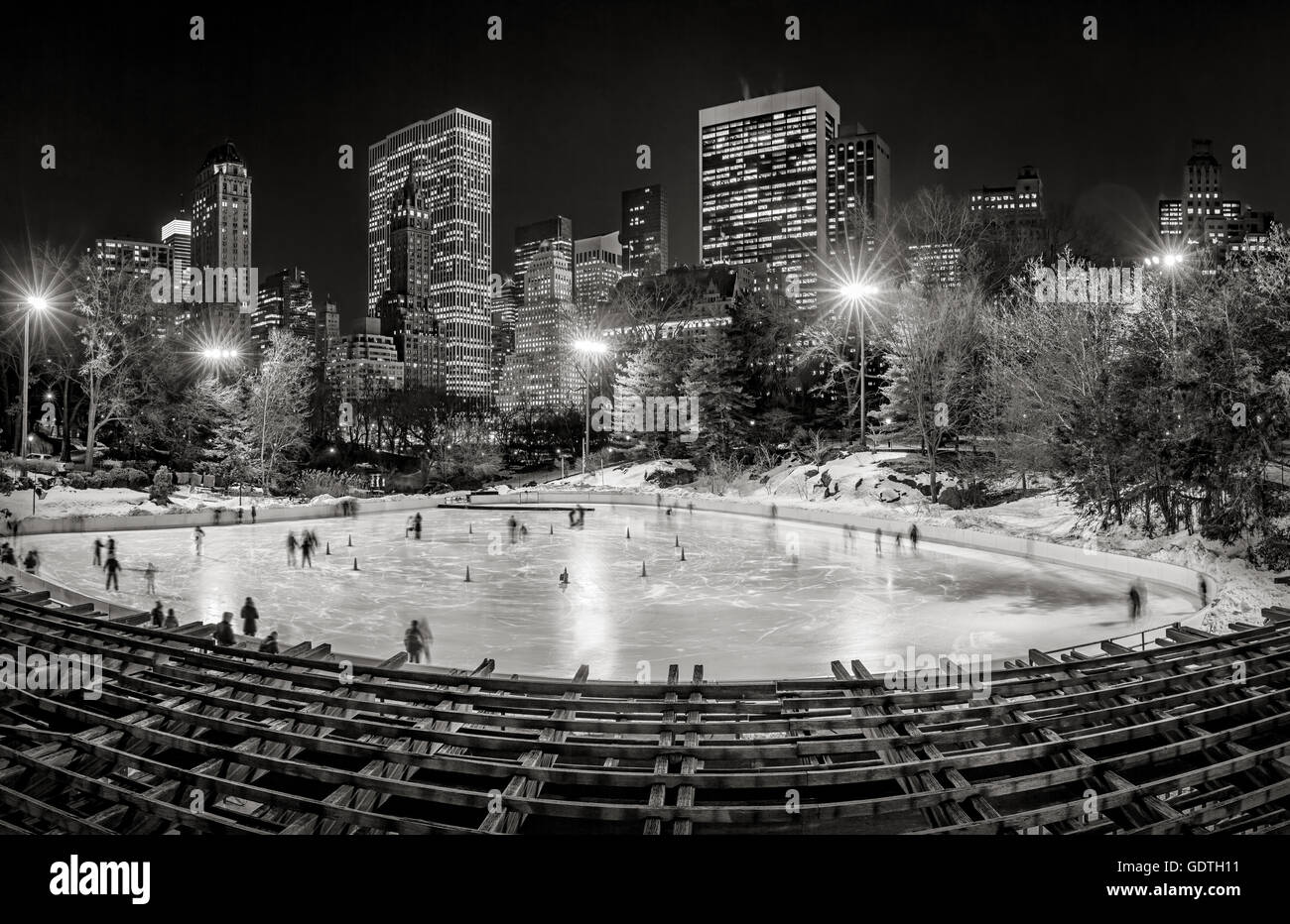 Wollman Eisbahn im Central Park mit Midtown Manhattan Wolkenkratzer in der Nacht in schwarz & weiß. New York City Stockfoto