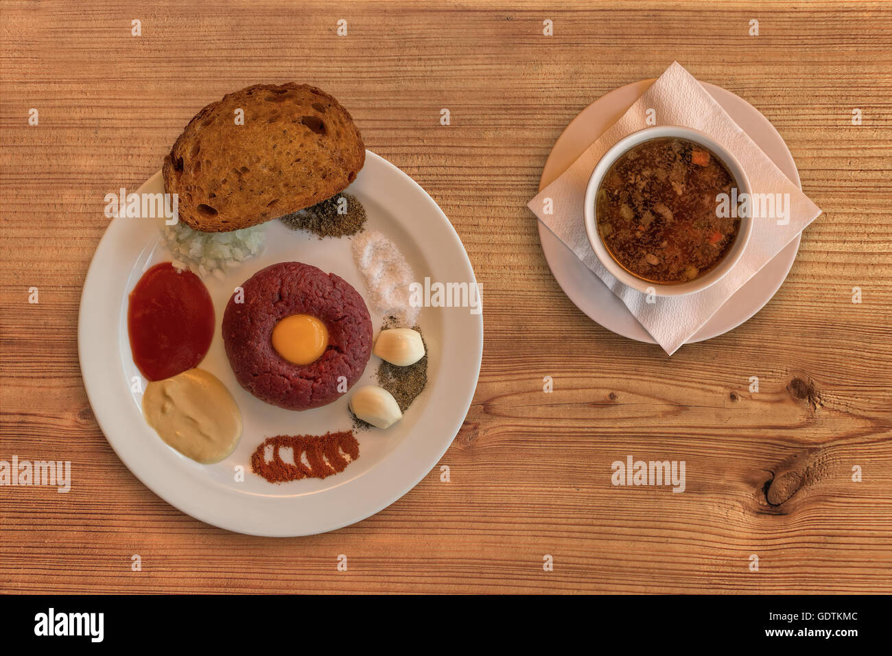 Flache Lay rohes Rindfleisch. Lecker Steak Tartare. Klassische Tatar auf rustikalen Holztisch mit einer Rinderbrühe. Zutaten: Rohe Biene Stockfoto