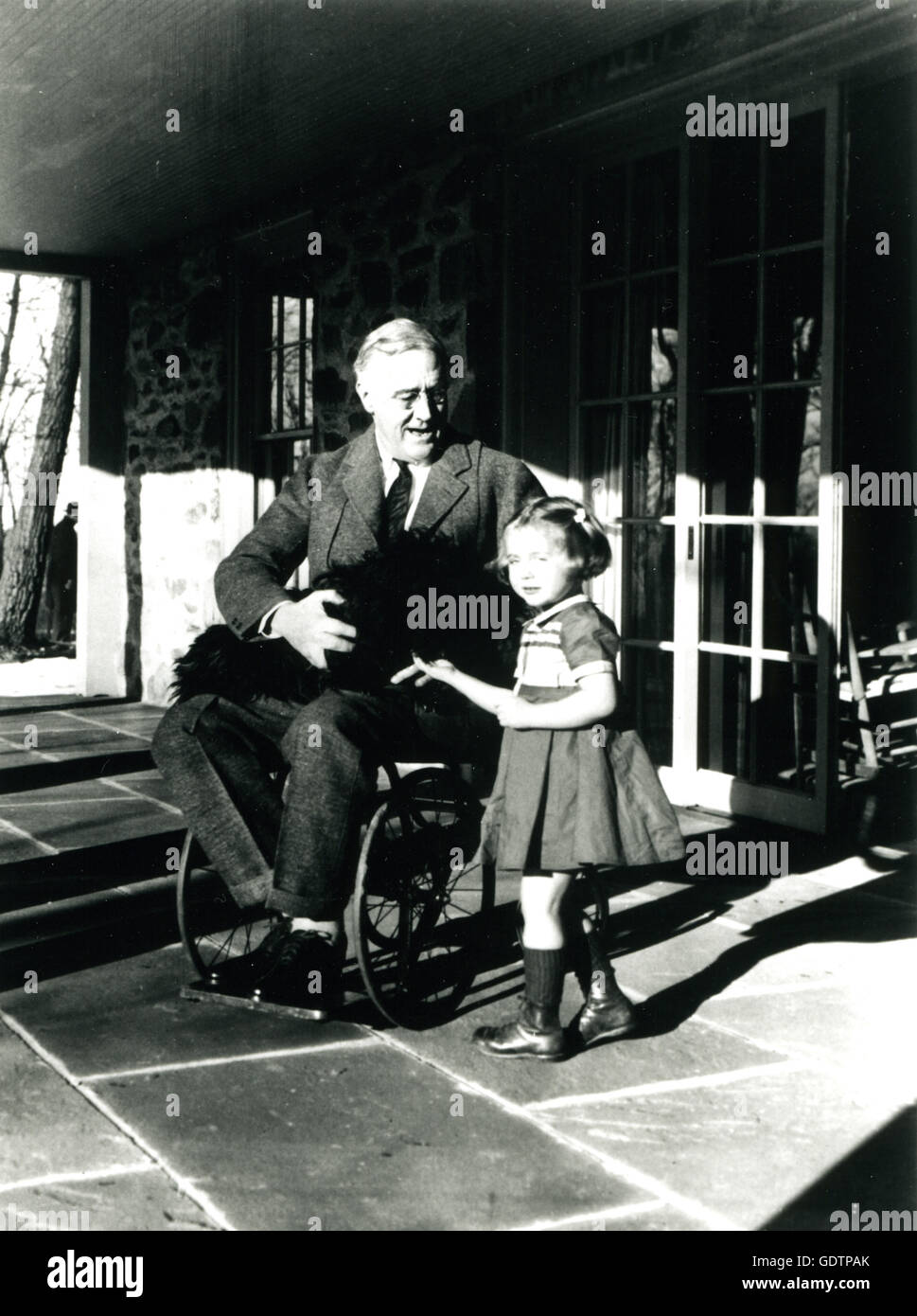 Präsident Franklin D. Roosevelt mit seinem Hund Fala und Ruthie Bie, im oberen Cottage. Das Foto ist einer von nur zwei, die Präsident Roosevelt in seinem Rollstuhl zu zeigen. Foto von Margaret Suckley. Stockfoto