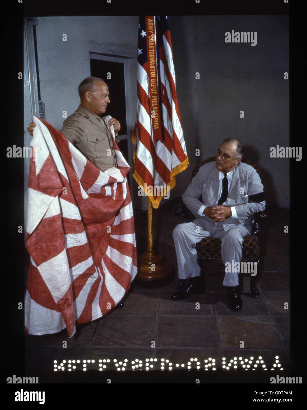 Roosevelt untersucht japanischer Flagge von Marine Corps Kommandanten Generalleutnant Thomas Holcomb, im Weißen Haus statt. Die Flagge wurde von einer Marine-Abteilung während der Schlacht von Makin Island gefangen genommen. Stockfoto