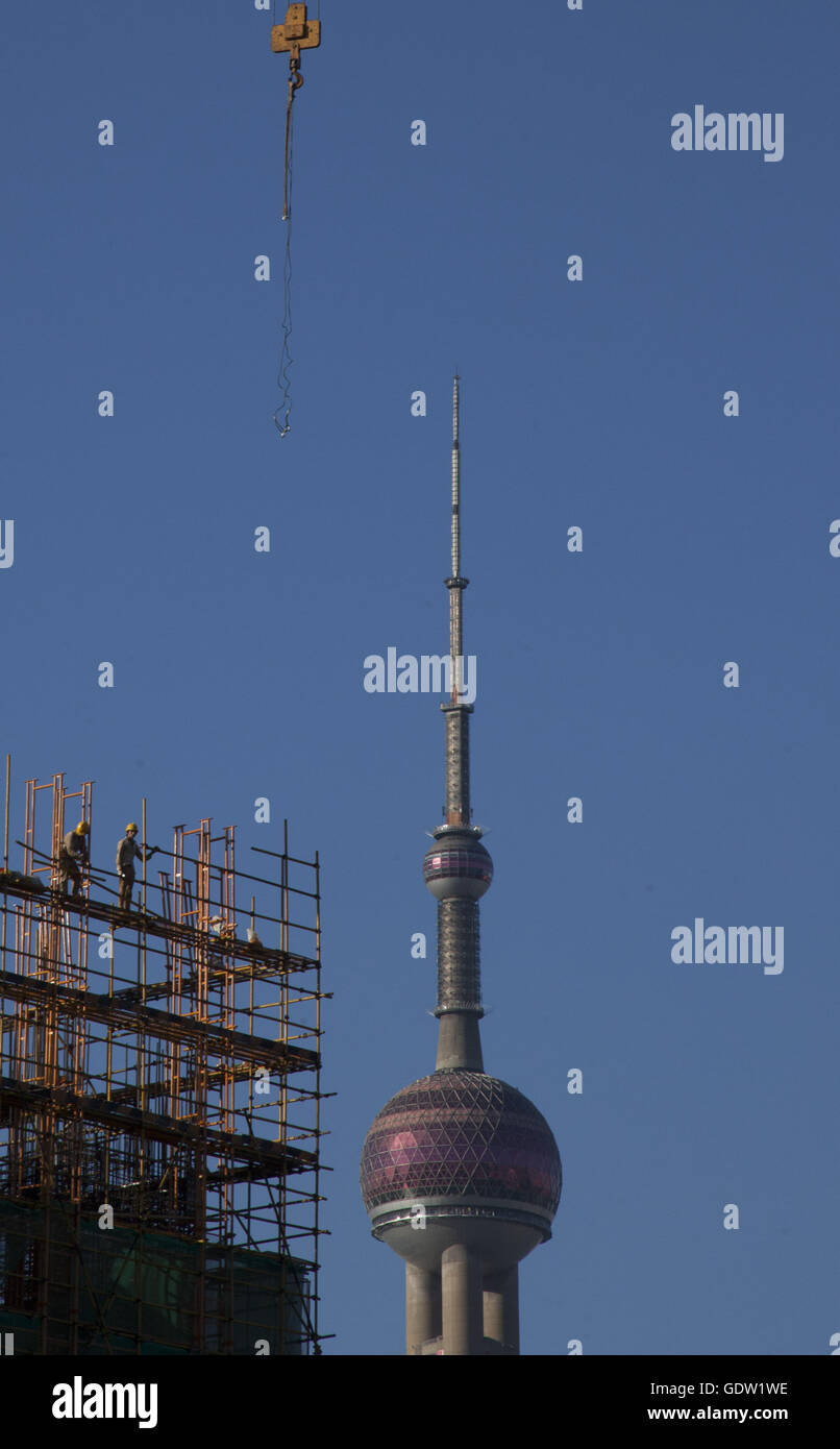 Bautrupps bauen ein Gebäude am Bund mit Oriental Pearl Tower im Hintergrund Stockfoto
