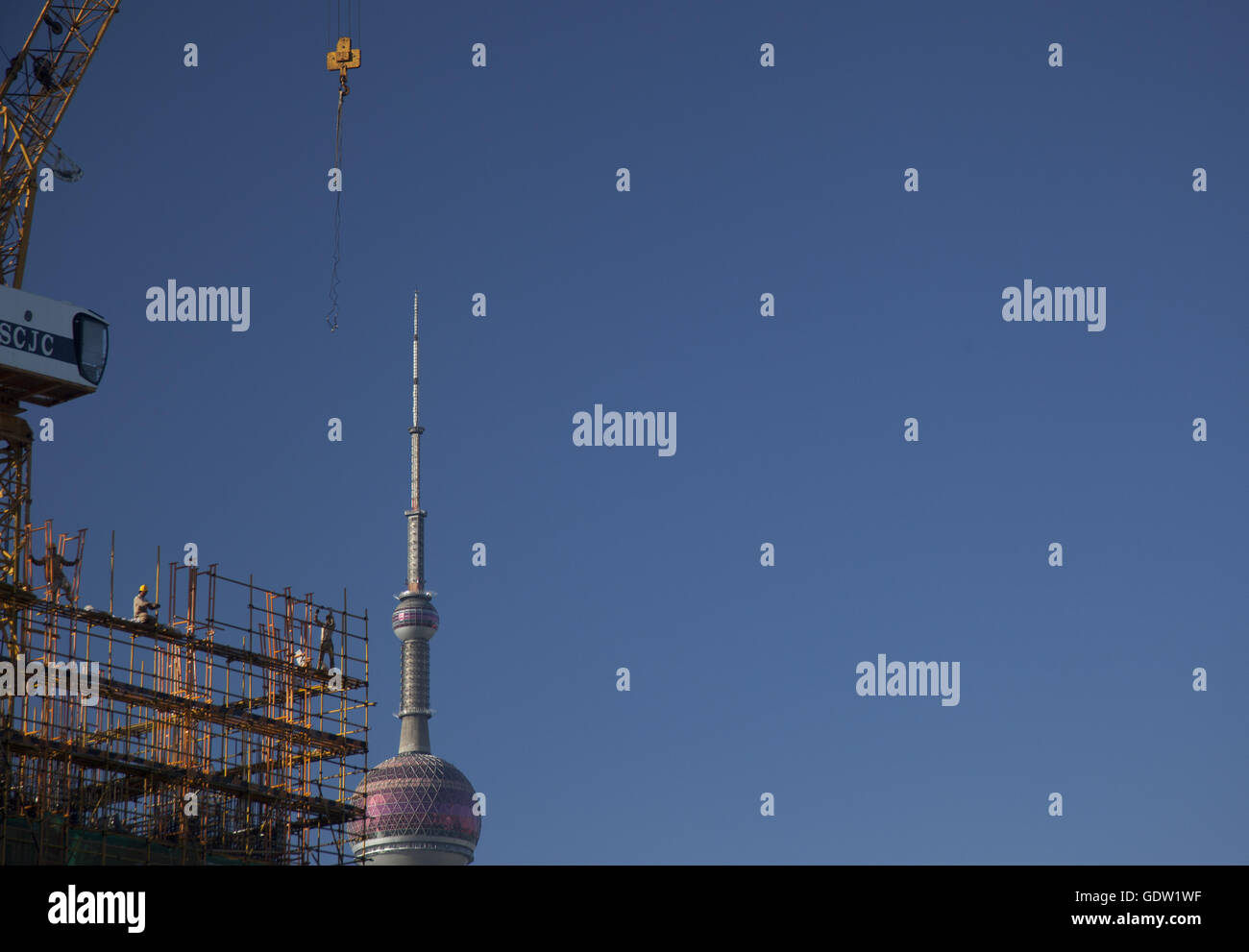 Bautrupps bauen ein Gebäude am Bund mit Oriental Pearl Tower im Hintergrund Stockfoto