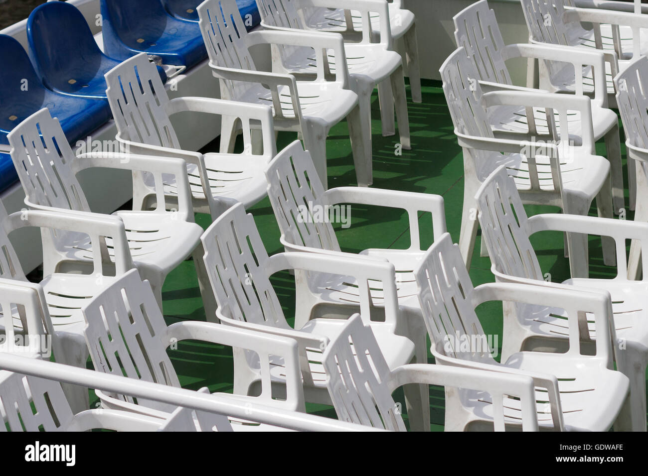 viele leere weiße Plastikstühle in Reihen Stockfoto