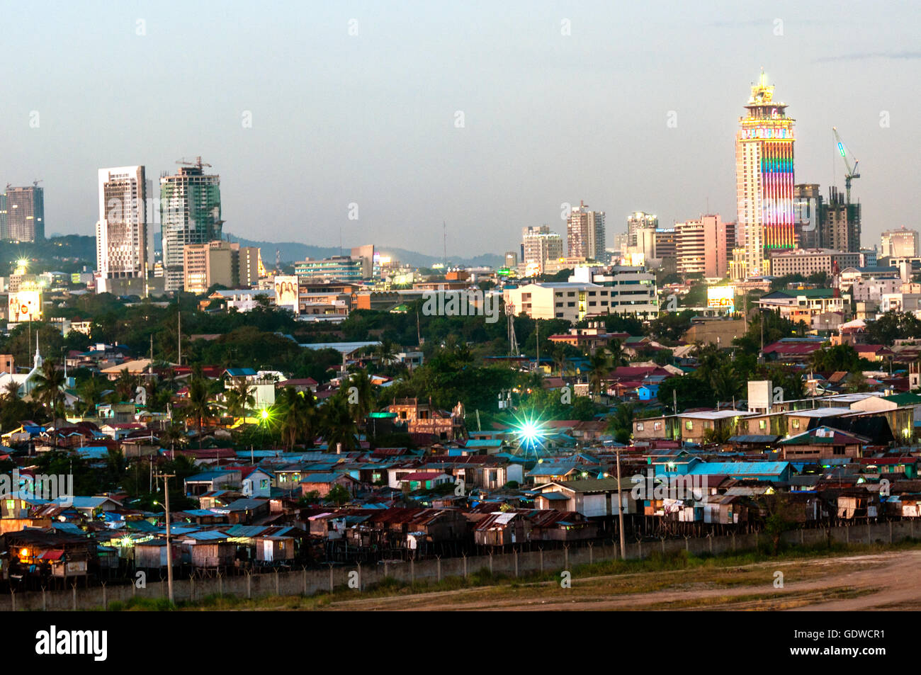 Luftaufnahme der Skyline der Stadt in der Abenddämmerung mit preiswerten Wohnungen im Vordergrund, gesehen vom Südwesten, Cebu City, Philippinen Stockfoto