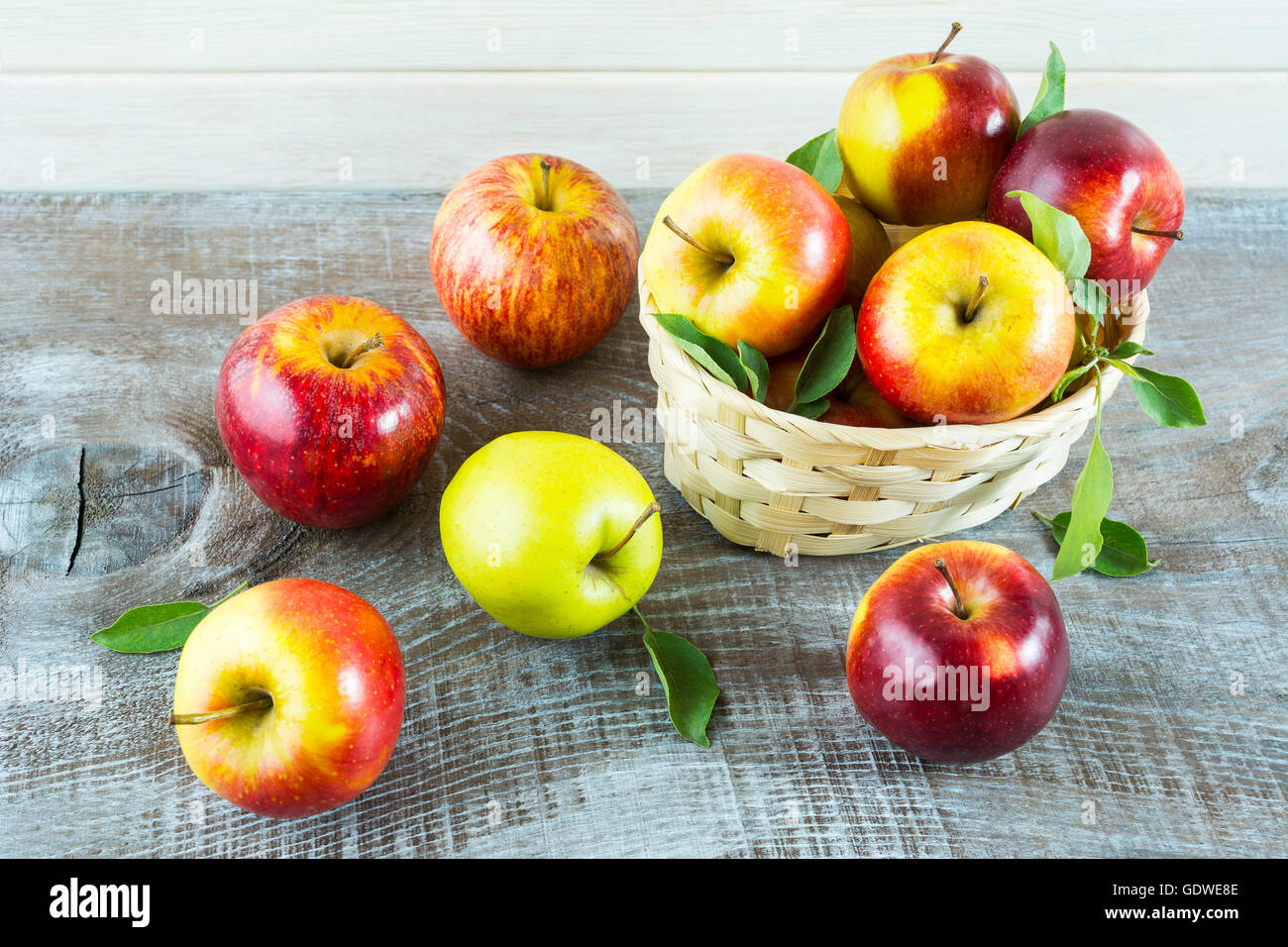 Frische Äpfel im Korb auf dem rustikalen Hintergrund. Reife Früchte als vegetarisches Essenskonzept. Gesunde Ernährung-Konzept mit frischen Stockfoto