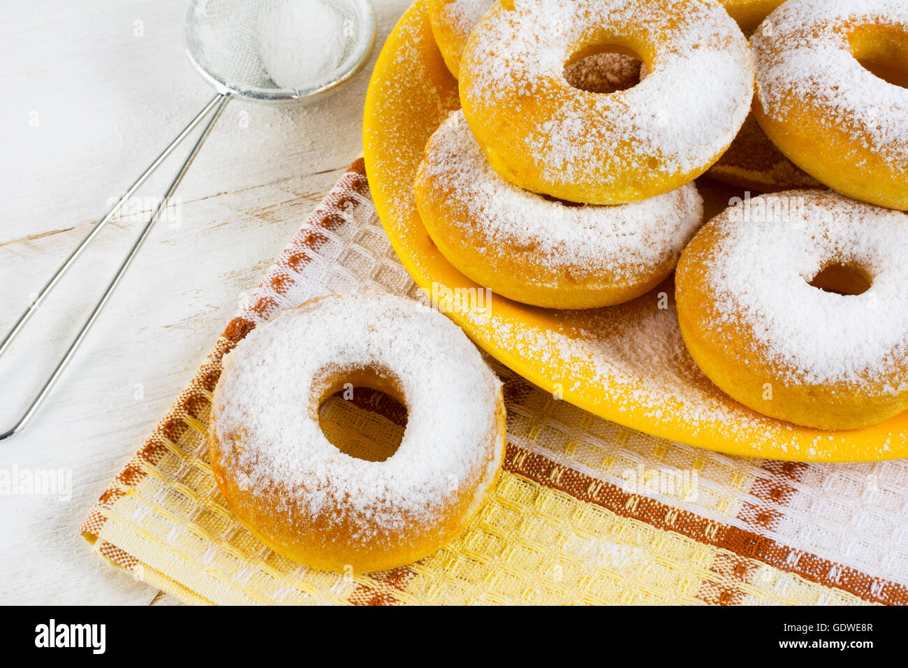 Hausgemachte süße Donuts mit Puderzucker auf karierte Serviette. Hanukkah süße Krapfen. Süßes Dessert Gebäck Krapfen. Stockfoto
