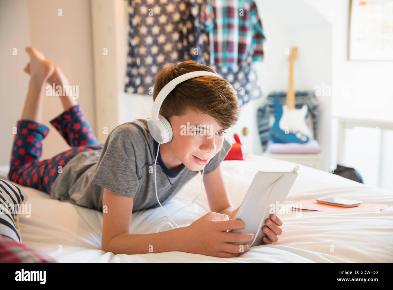 Junge mit Kopfhörern Musik hören auf digital-Tablette Stockfoto