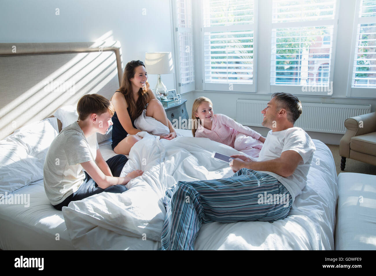 Familie im Pyjama auf Bett Stockfoto