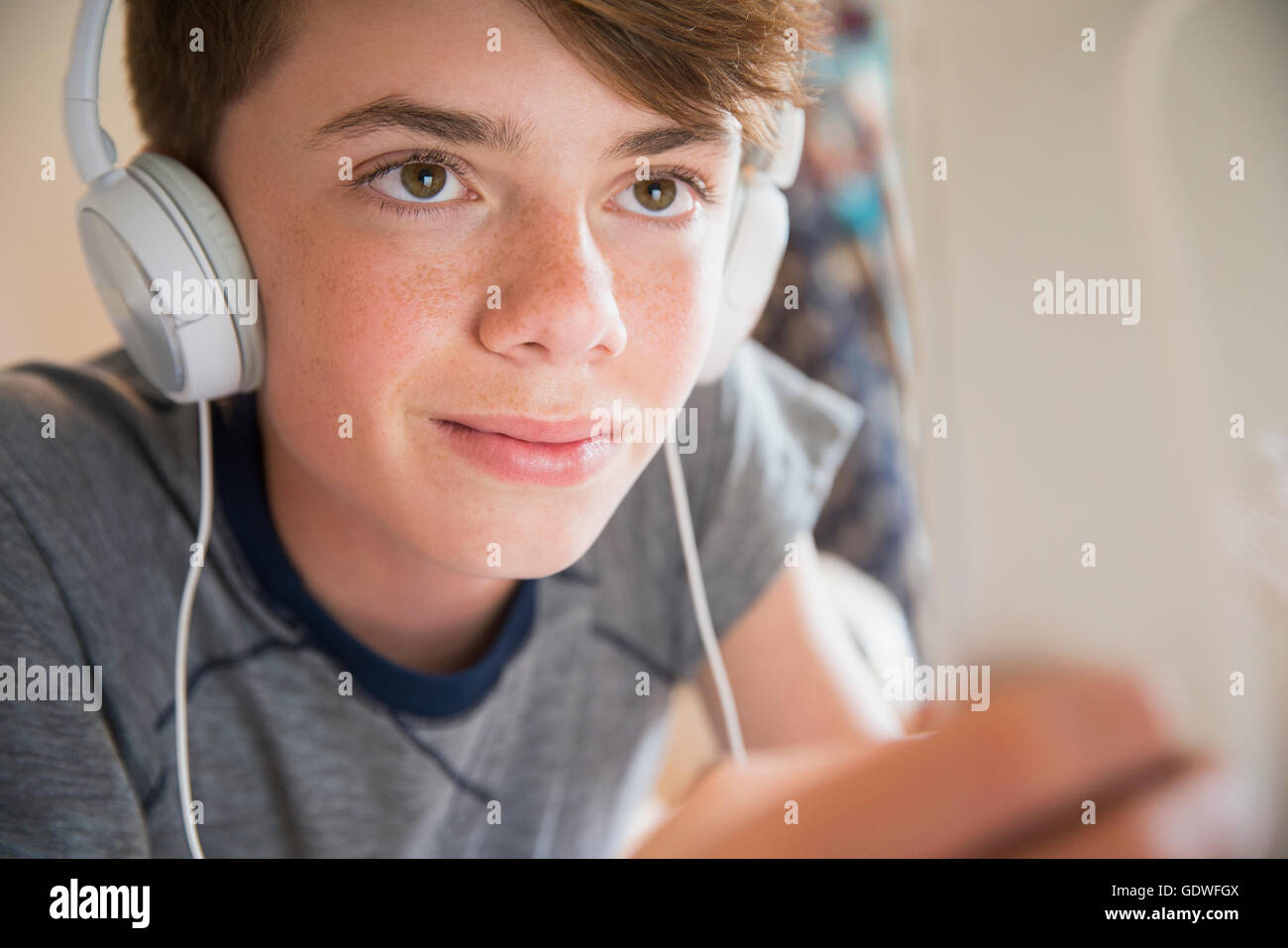 Junge mit Kopfhörern Musik hören auf digital-Tablette hautnah Stockfoto