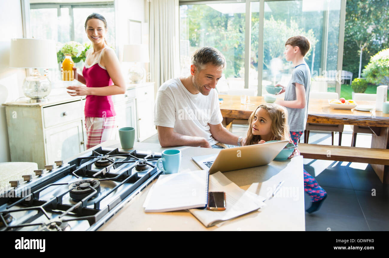 Familie mit Frühstück und Laptop in Morgen Küche Stockfoto