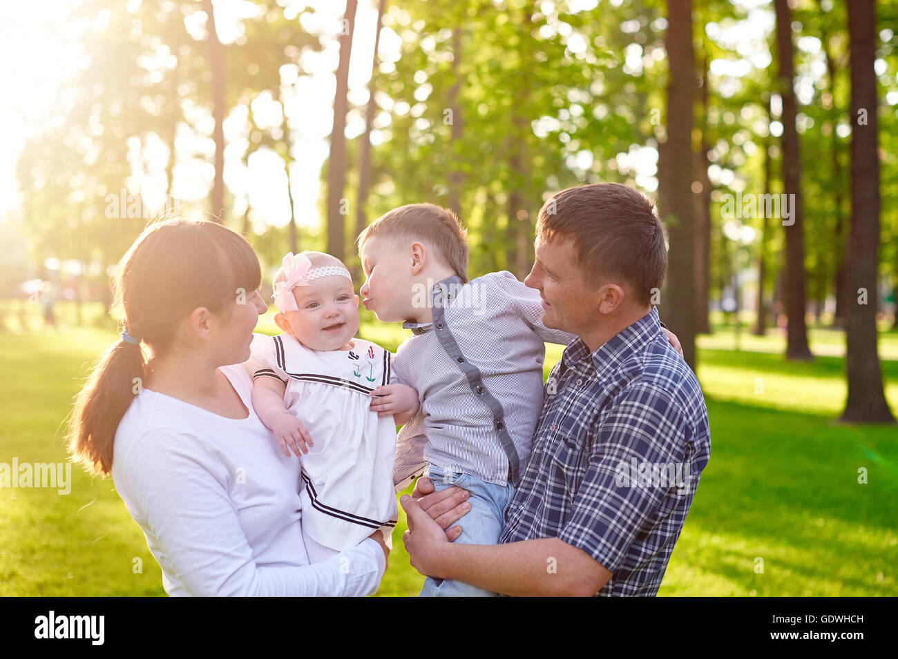 Glückliche junge Familie mit Kindern geht im Sommerpark Stockfoto