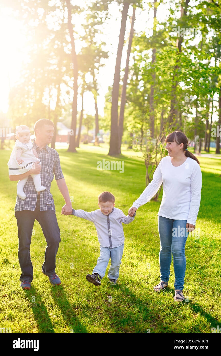 Glückliche junge Familie mit Kindern geht im Sommerpark Stockfoto