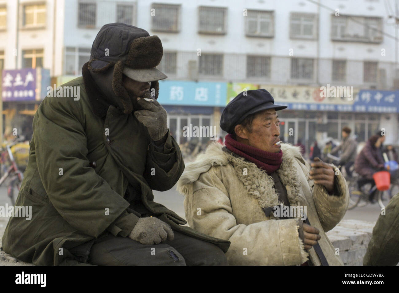 Zwei Arbeiter rauchen Zigaretten in einer Straße Stockfoto