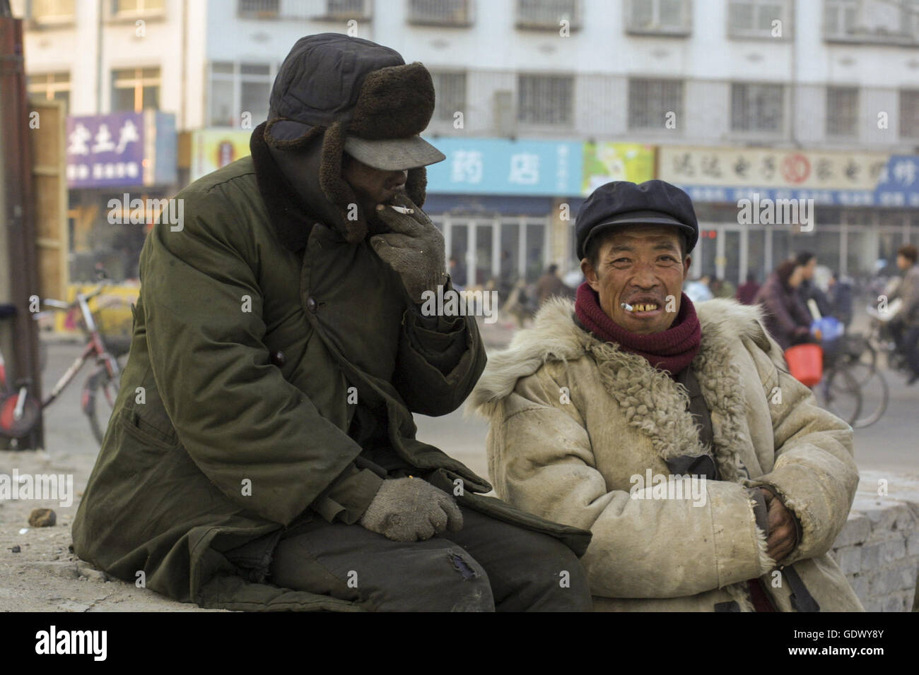 Zwei Arbeiter rauchen Zigaretten in einer Straße Stockfoto