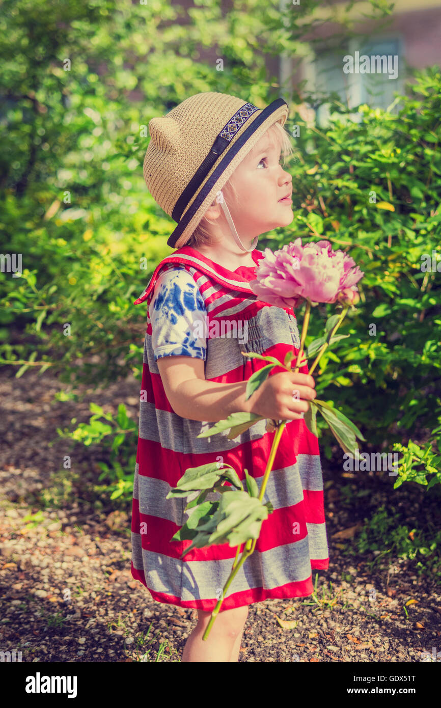 Wunderschönes kleines Mädchen, die eine Blume im Garten Stockfoto