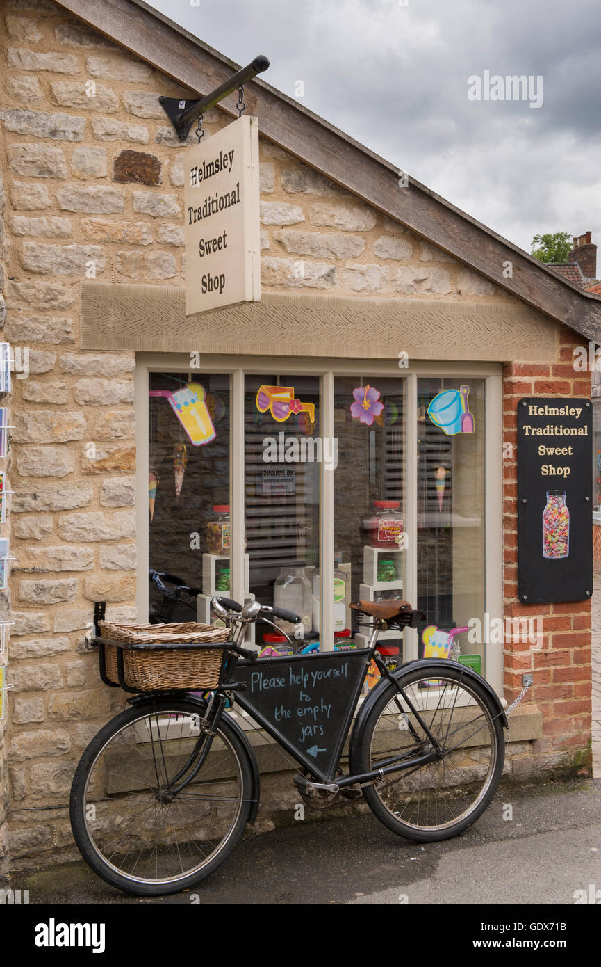 Helmsley traditionelle Sweet Shop, Helmsley, North Yorkshire - süße Gläser im Fenster und alte altmodische Lieferung Motorrad außerhalb. Stockfoto