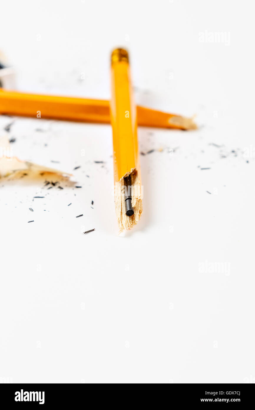 Gebrochene Bleistift mit Späne auf weißem Hintergrund. Vertikales Bild. Stockfoto