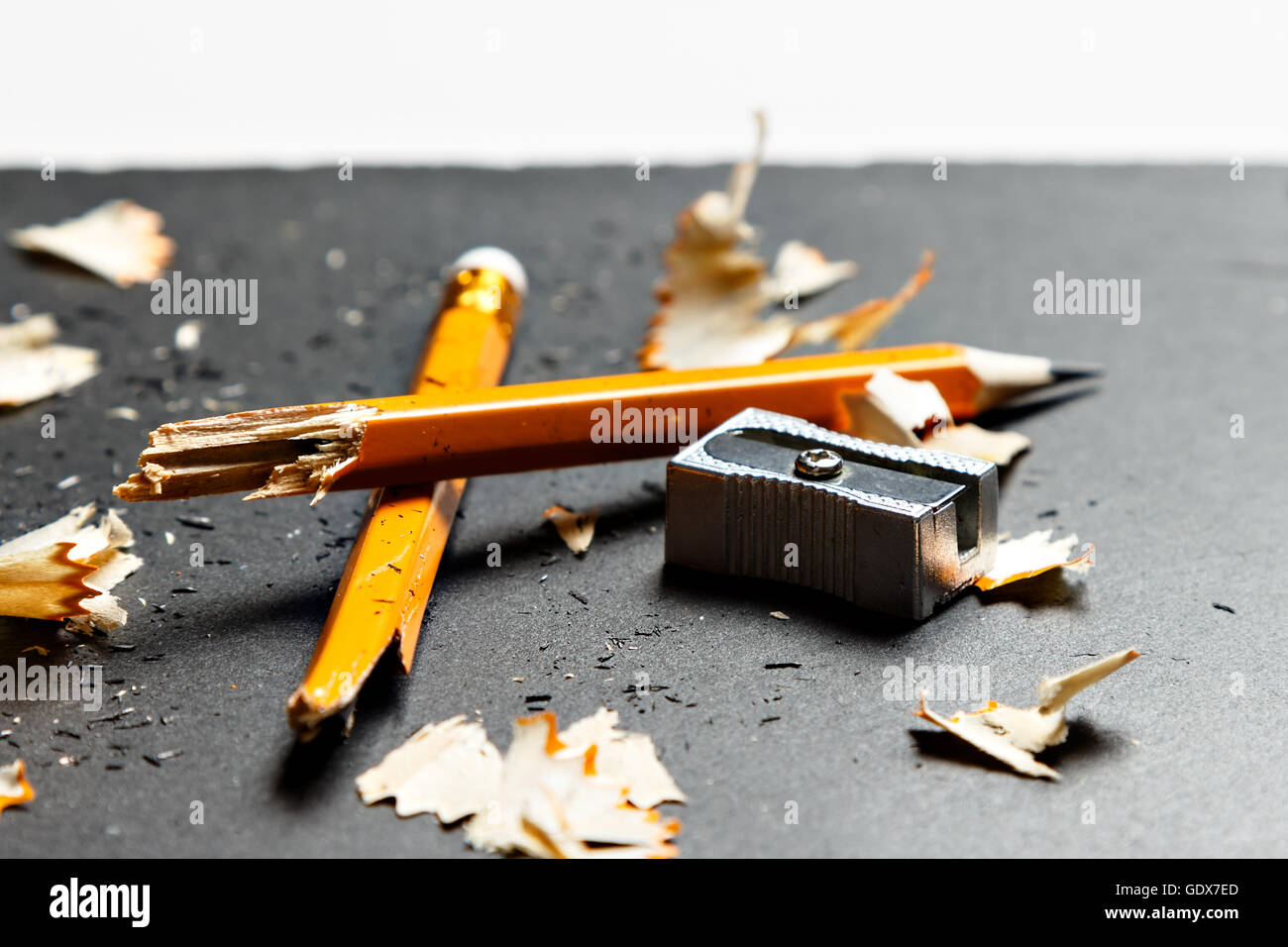 Gebrochene Bleistift mit Metall Spitzer und Späne auf schwarzem Hintergrund. Horizontales Bild. Stockfoto