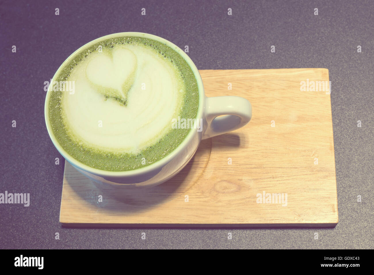 Tasse Kaffee auf hölzerne Latte Kunst, grüner Tee Milch, vintage Stockfoto