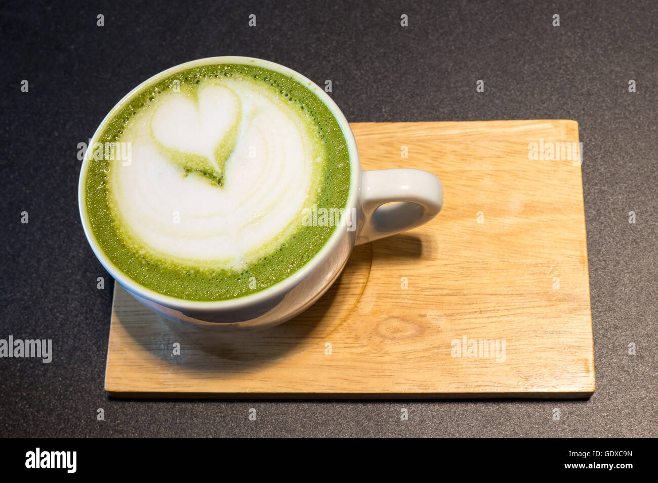 Tasse Latte Kunst auf Holz, grüner Tee Milch Kaffee Stockfoto