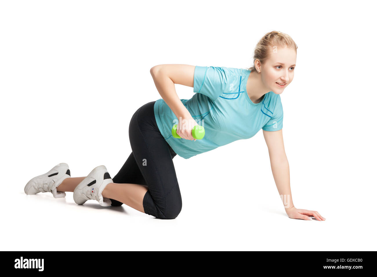 Sportliche junge Frau klappt mit grünen Hanteln Stockfoto