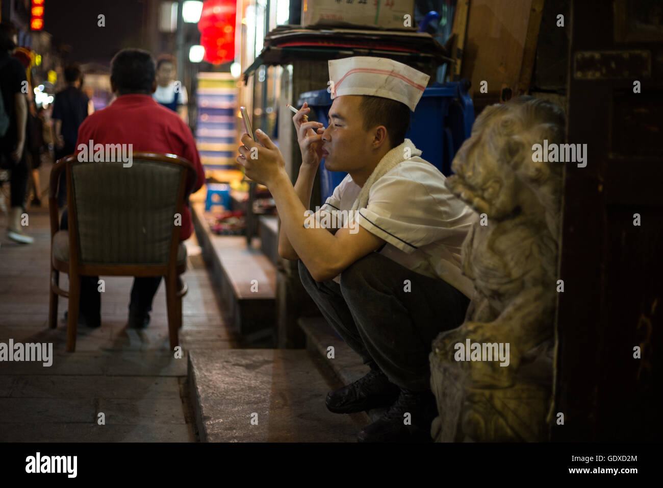 Chinesische Jugendliche spielen Sie mit ihren Smartphones und soziale Netzwerke in Peking, China Stockfoto