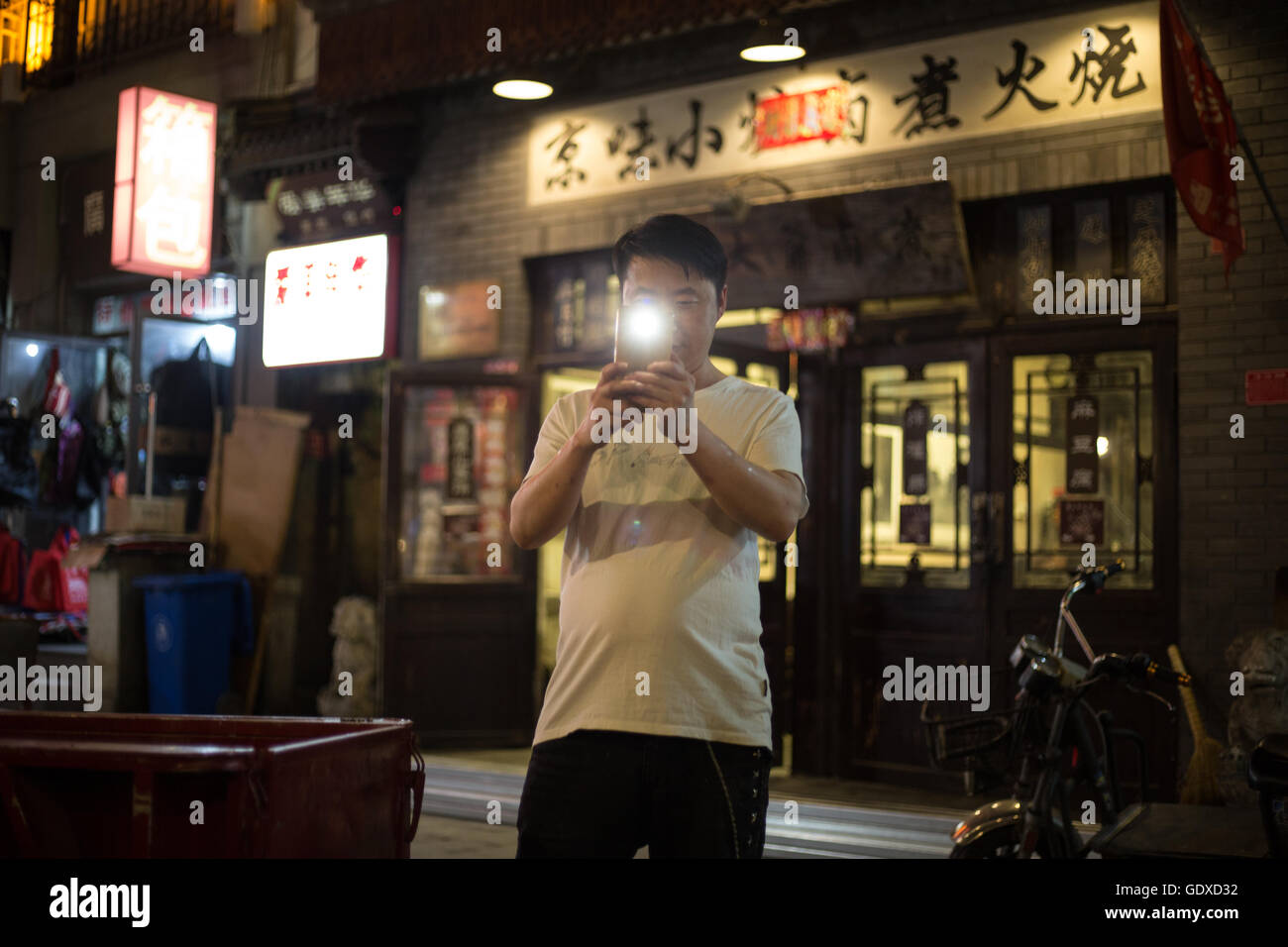 Mann Fotos Tourist mit seinem Smartphone-Kamera im Shitou und Dashilar Hutong, in Peking, China. Stockfoto