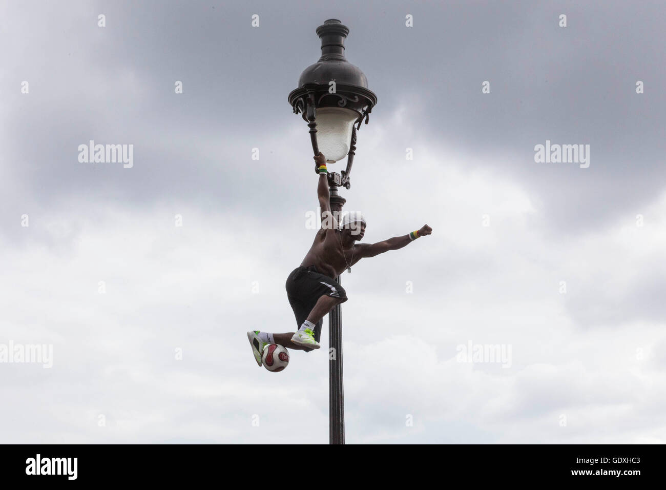 Akrobat jongliert mit einem Fußball auf einen Laternenpfahl in Montmartre, Paris, Frankreich, 2014 Stockfoto