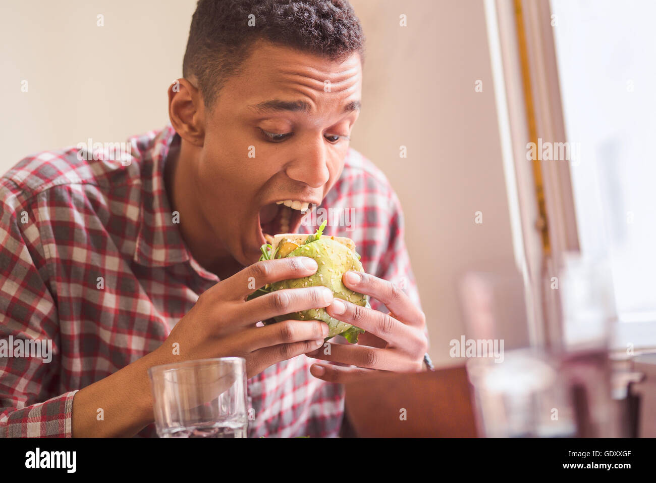Mann isst Vegan Burger im restaurant Stockfoto