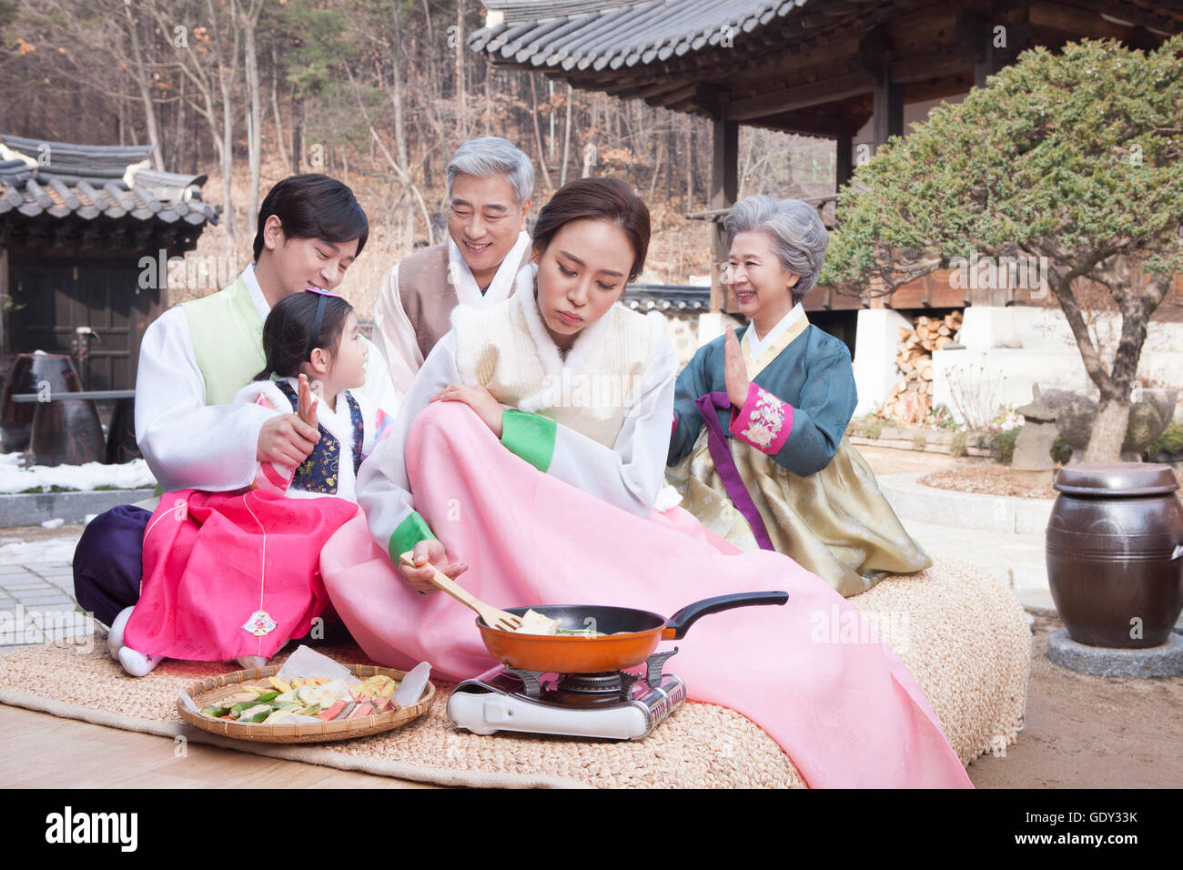 Stressig Koreanerin, Kochen und andere Familienmitglieder, die Spaß am traditionellen koreanischen Urlaub Stockfoto