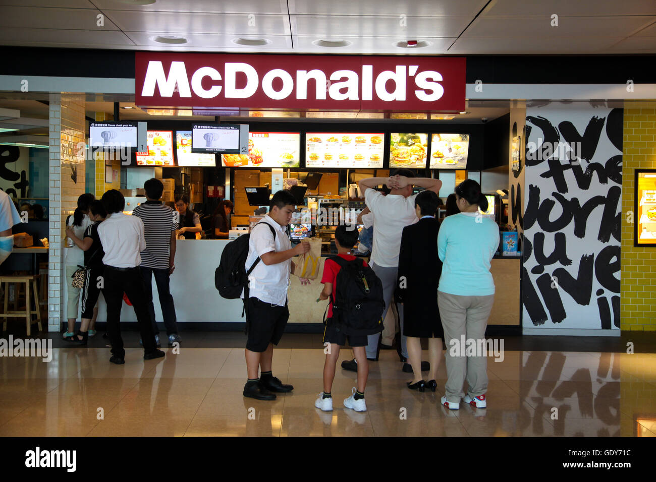 Chinesische Jugendliche queuing in McDonalds Kowloon, Hong Kong, China Stockfoto